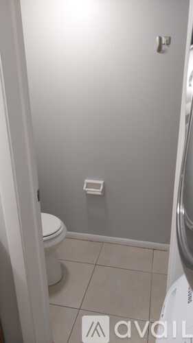 A small bathroom with a toilet and a washing machine.