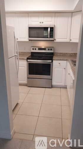 A kitchen with white cabinets and a black stove top oven.