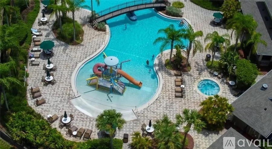 An aerial view of a pool with a slide and lounging areas.