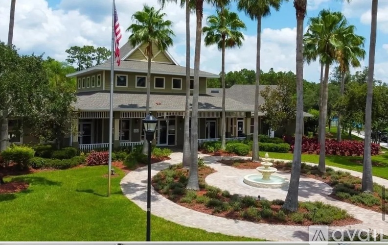 A building with a flag on top and a fountain in front.