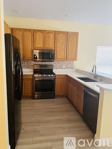A kitchen with wooden cabinets and black appliances.