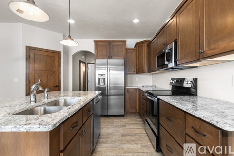 A kitchen with wooden cabinets and granite countertops.