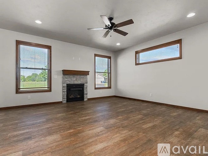 A spacious room with a fireplace and a ceiling fan.