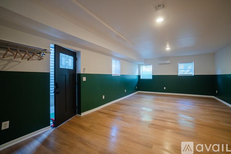 A room with wooden floors and a black door.