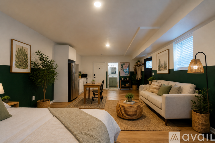 A well-lit, modern bedroom with a large bed and a green wall.