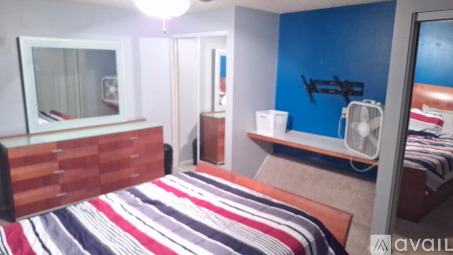 A bedroom with a bed, a mirror, and a window.