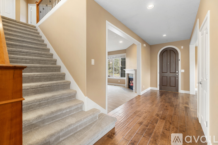 A staircase with a wooden banister leads to a room with a brown door.