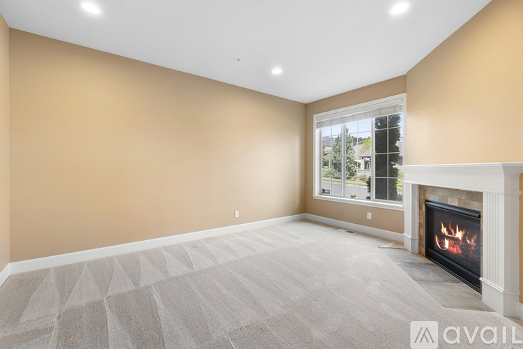 A living room with a fireplace and a carpeted floor.