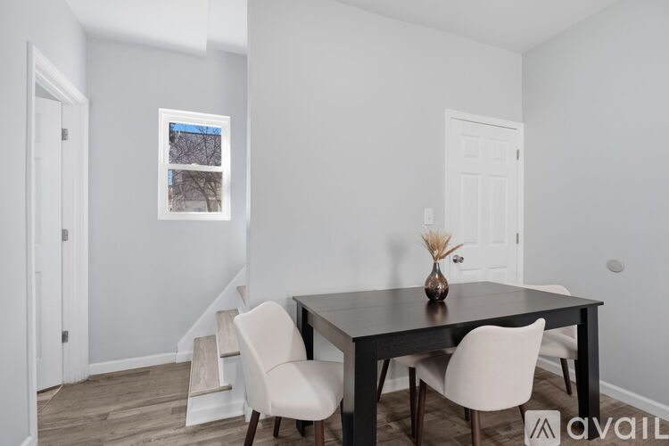 A dining room with a table and chairs.
