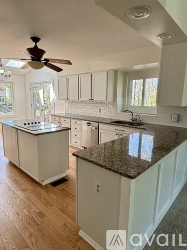 A kitchen with white cabinets and a granite countertop.