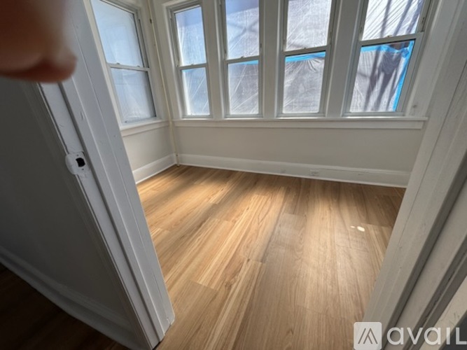 A room with wooden flooring and a window.