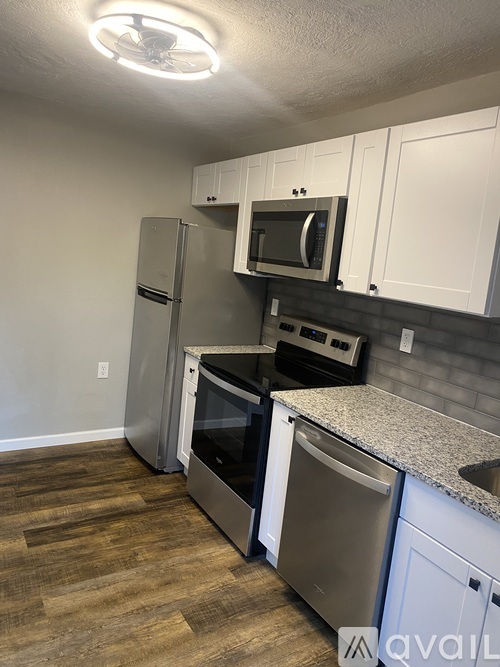 A kitchen with a refrigerator, oven, and microwave.