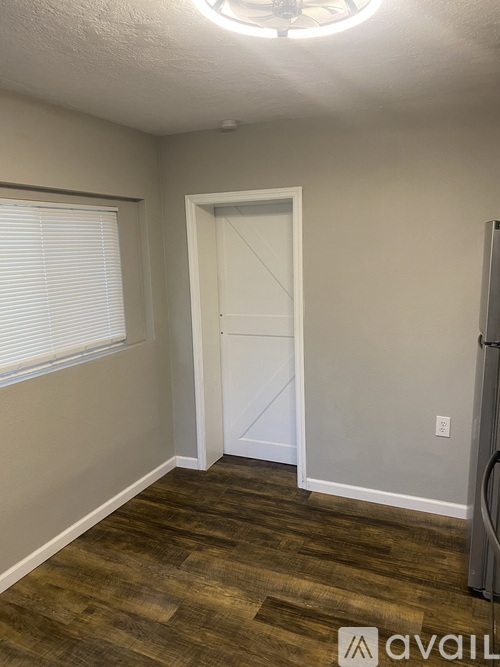 A room with a door and a window with blinds.