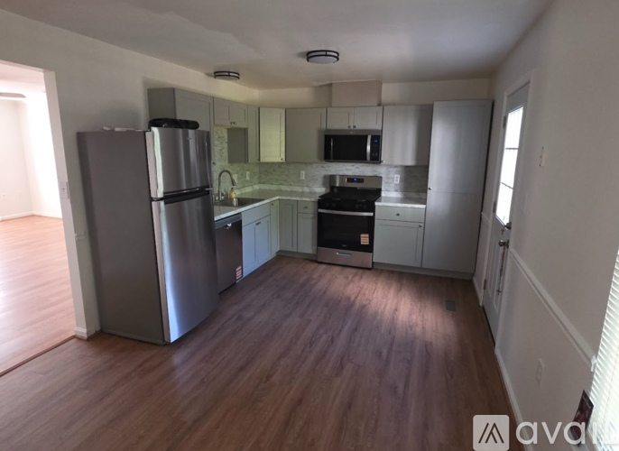 A kitchen with a refrigerator, oven, and microwave.