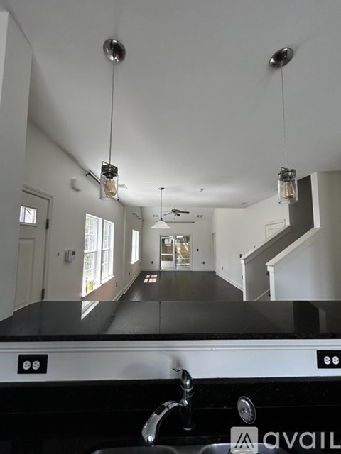 A kitchen with a black counter top and a stainless steel sink.
