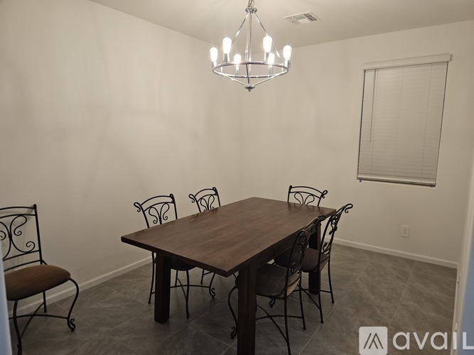 A dining room with a wooden table and chairs.