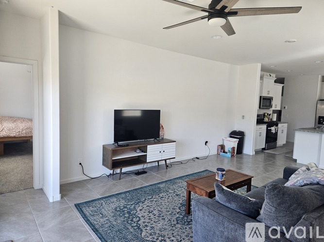 A living room with a grey couch and a television on a wooden stand.