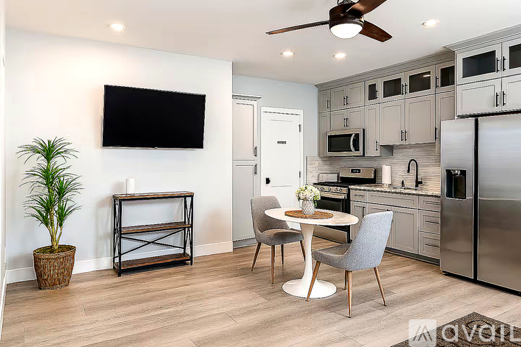 A modern kitchen with a dining table and chairs.