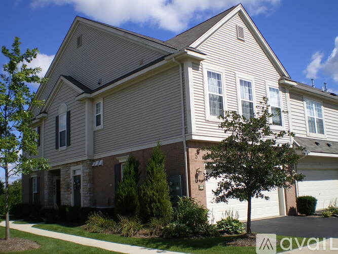 A house with a grey siding and a white garage door.