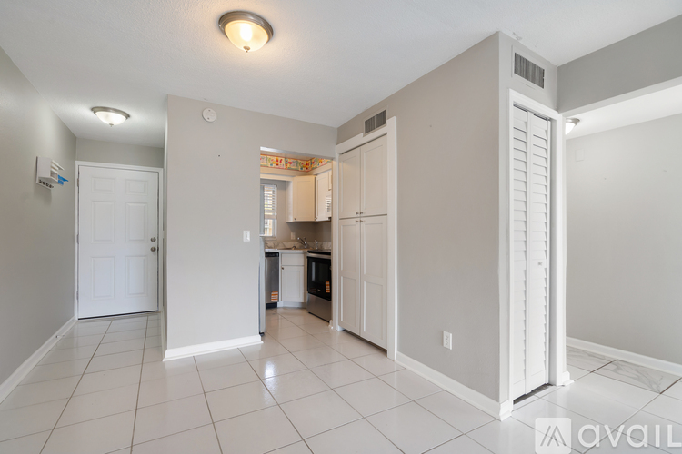A kitchen area with a refrigerator, cabinets, and a countertop.