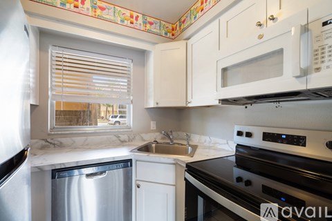 A kitchen with a stainless steel dishwasher and a black oven.