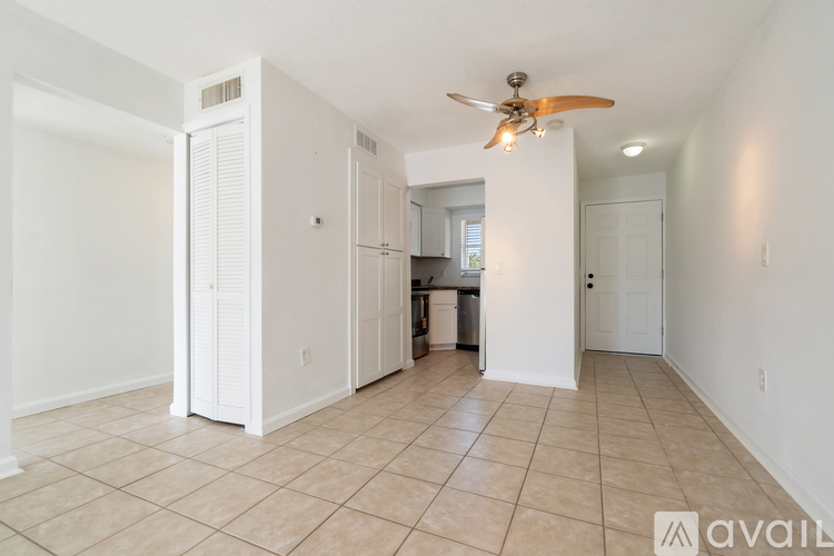 A spacious living room with a ceiling fan and tiled flooring.