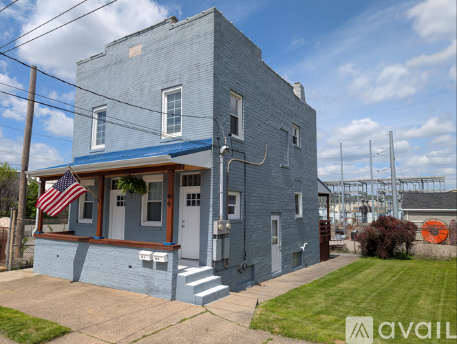A blue house with an American flag on the porch.