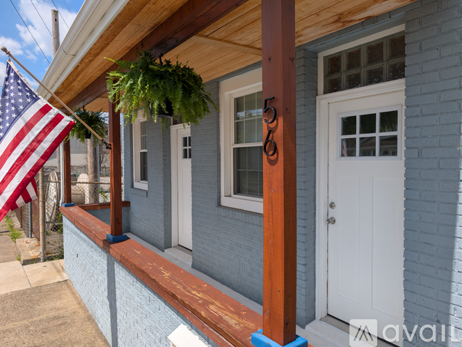 A house with a porch and an American flag hanging on the wall.