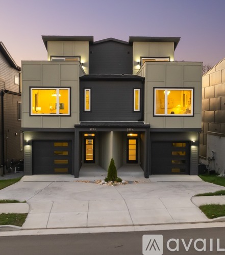 A modern house with a black and white exterior and a large front yard.