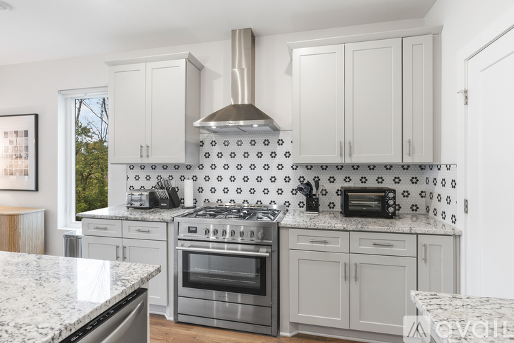A kitchen with a marble countertop and a stove top oven.