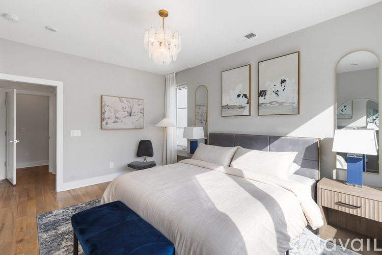 A bedroom with a large bed and a chandelier.