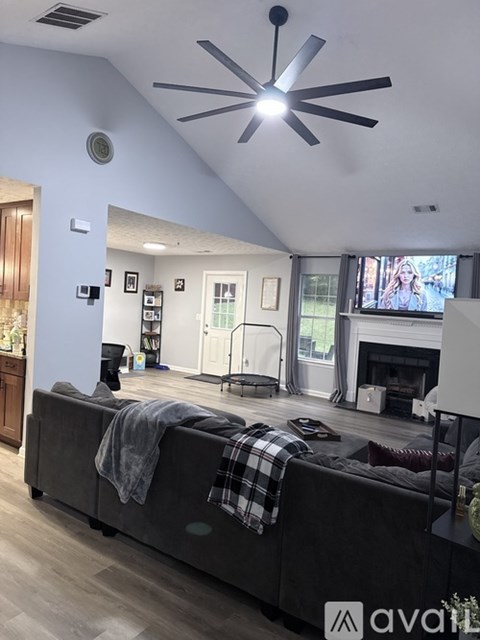 A living room with a grey couch and a ceiling fan.