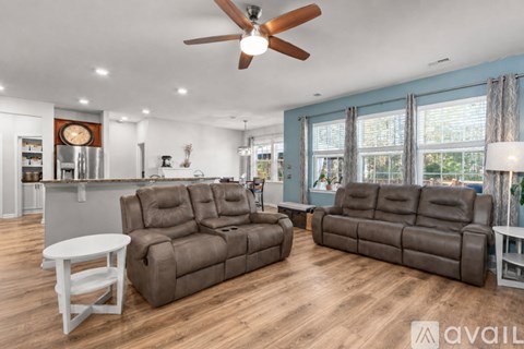 A living room with two brown leather sofas and a white table.