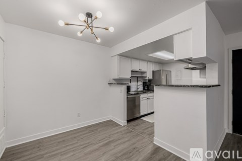 A kitchen with a white counter and stainless steel appliances.