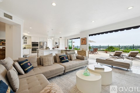 A living room with a large couch and a view of the ocean.