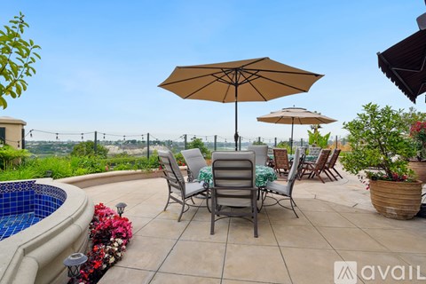 A patio with a table and chairs and a pool.