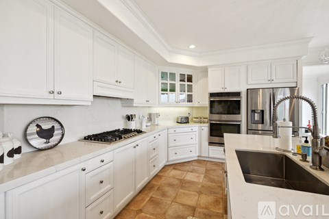 A kitchen with white cabinets and a tile floor.