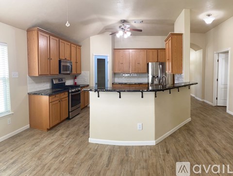 A kitchen with wooden cabinets and a black countertop.
