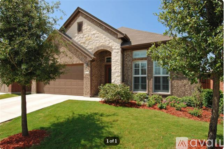 A house with a brown garage door and a stone wall.
