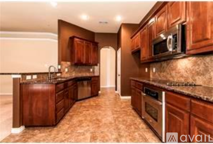 A kitchen with brown cabinets and a granite countertop.