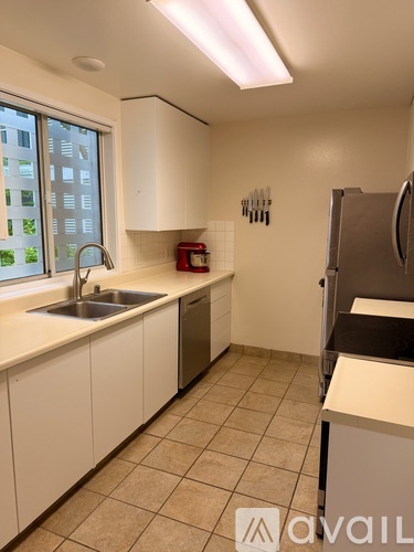 A kitchen with white cabinets and a stainless steel refrigerator.