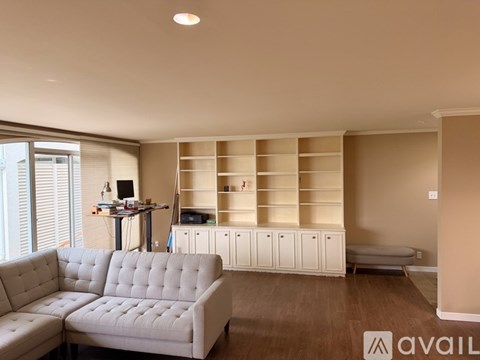 A living room with a grey sofa and a wooden floor.