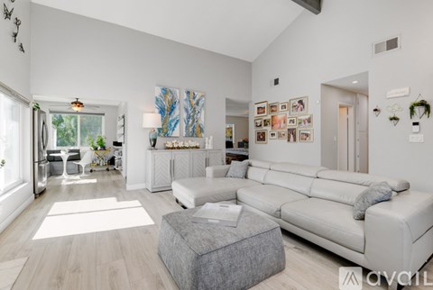 A living room with a grey sofa and a grey ottoman.