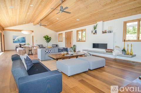 A living room with a blue couch and a wooden floor.