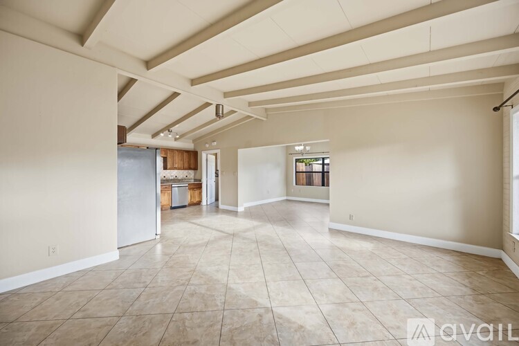 A spacious room with beige walls and a tiled floor.