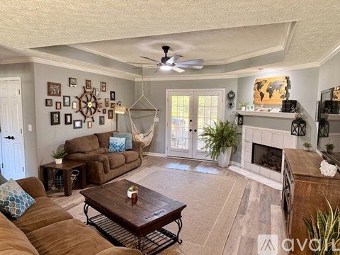 A living room with a brown couch and a fireplace.