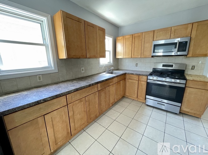A kitchen with wooden cabinets and a black stove top oven.