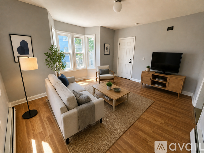 A living room with a couch, a coffee table, a lamp, a plant, and a television.