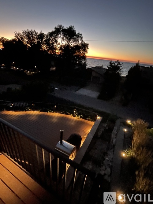 A sunset view from a balcony with a pool.