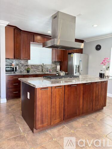 A kitchen with wooden cabinets and a marble countertop.